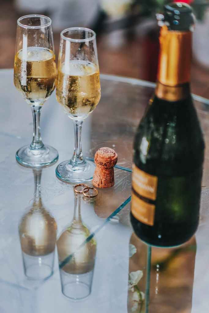 The image shows an opened bottle of sparkling wine with two glasses of it already poured. 4 potential health benefits of prosecco.